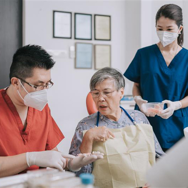 A group of individuals in scrubs is gathered around a patient, working together to deliver medical assistance.